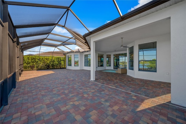 view of patio with ceiling fan and a lanai