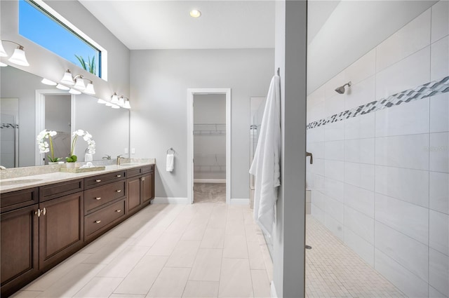 bathroom featuring tiled shower, tile patterned flooring, and vanity