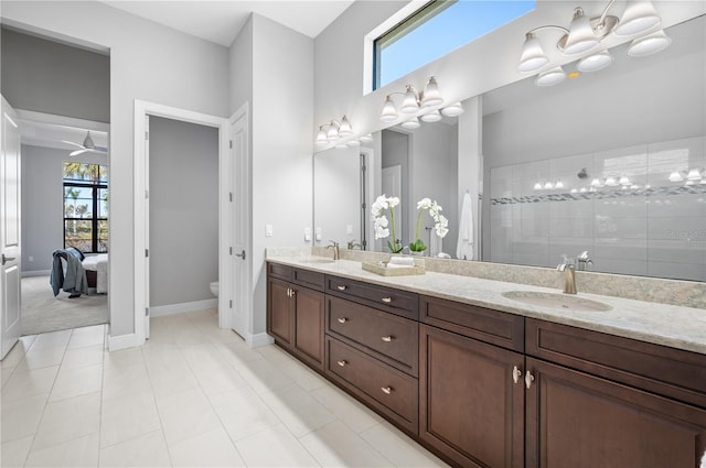 bathroom with vanity, toilet, tiled shower, and tile patterned floors