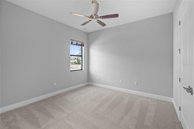 empty room featuring ceiling fan and light carpet