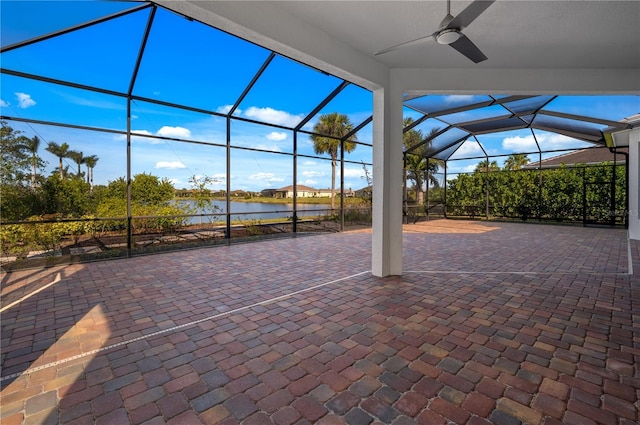 view of patio featuring ceiling fan, glass enclosure, and a water view