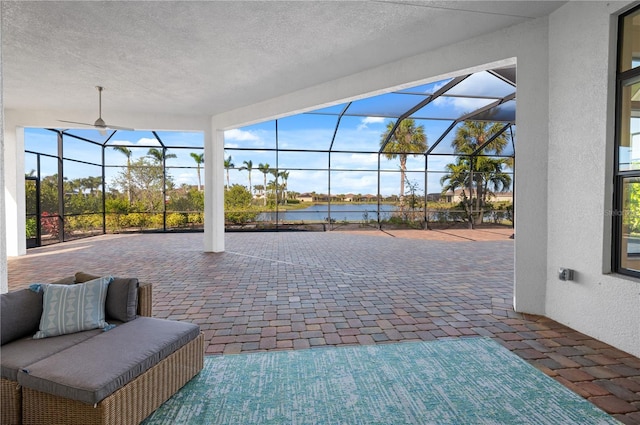 view of patio with a water view and a lanai