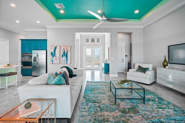 living room featuring crown molding, a tray ceiling, and french doors