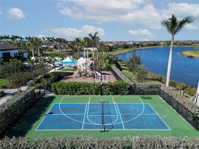 view of sport court featuring a playground and a water view