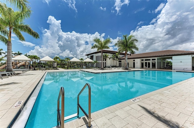 community pool with a gazebo and a patio area