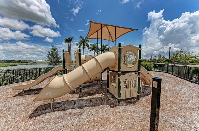communal playground featuring fence and a water view