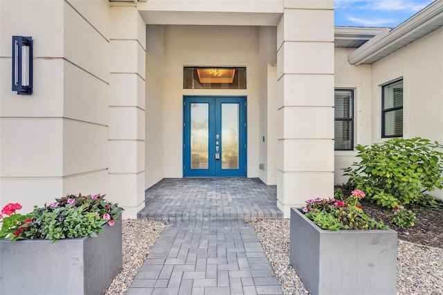 view of exterior entry featuring stucco siding and french doors