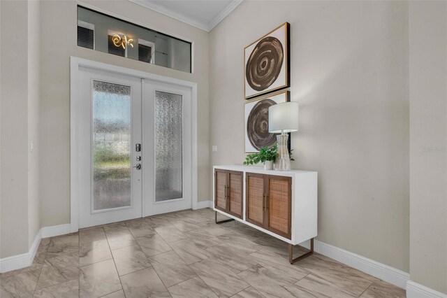 entryway with crown molding, marble finish floor, baseboards, and french doors