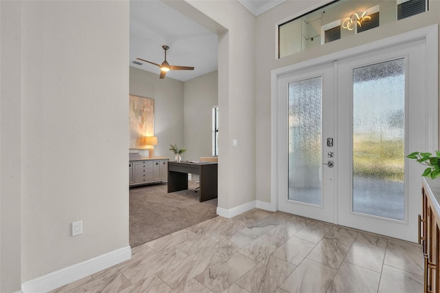 foyer entrance with ceiling fan, marble finish floor, french doors, light colored carpet, and baseboards