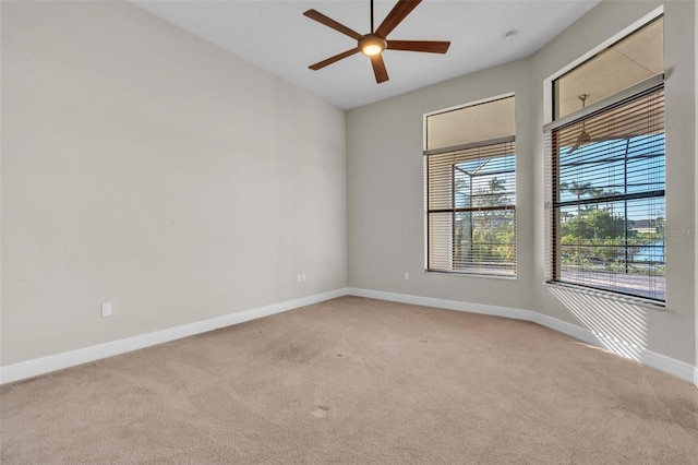 spare room with baseboards, a ceiling fan, and light colored carpet