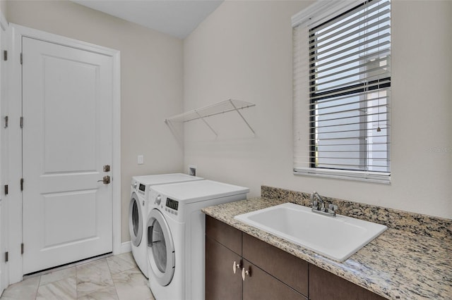 laundry room featuring a sink, baseboards, marble finish floor, independent washer and dryer, and cabinet space