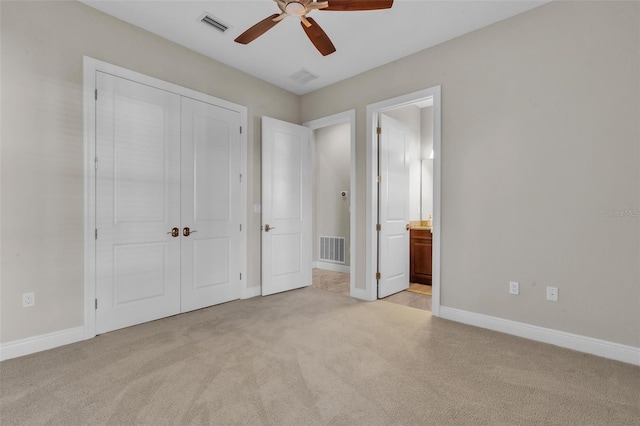 unfurnished bedroom featuring light colored carpet, baseboards, visible vents, and a closet