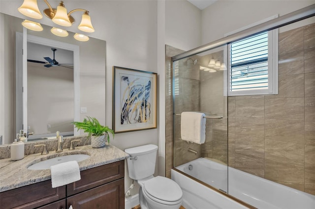 full bathroom featuring ceiling fan with notable chandelier, vanity, bath / shower combo with glass door, and toilet