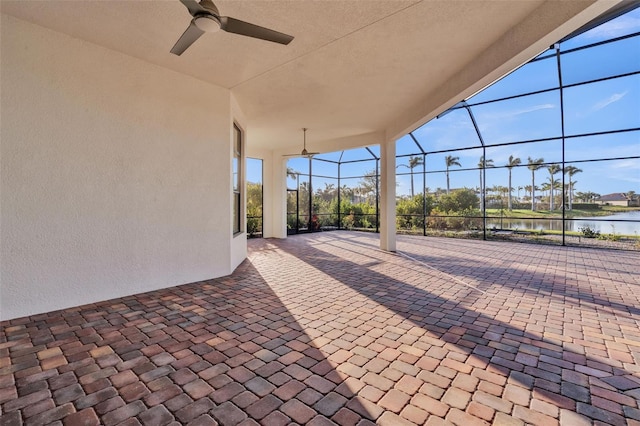 view of patio / terrace with glass enclosure, a water view, and ceiling fan