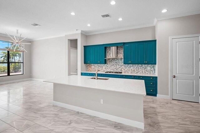 kitchen with marble finish floor, blue cabinets, a sink, wall chimney exhaust hood, and gas stovetop