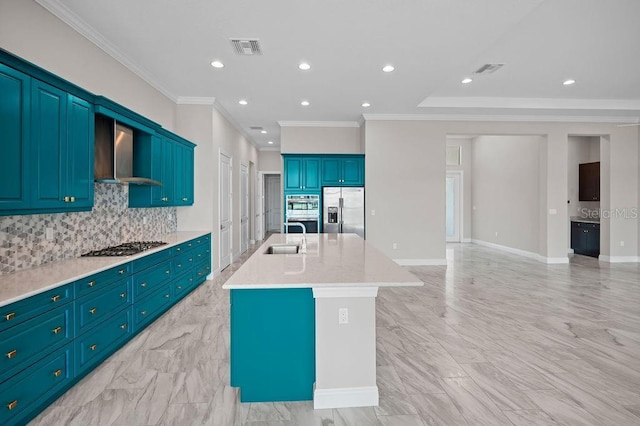 kitchen with stainless steel appliances, tasteful backsplash, visible vents, wall chimney range hood, and an island with sink