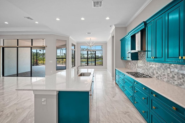 kitchen featuring wall chimney exhaust hood, a sink, stainless steel gas stovetop, marble finish floor, and ornamental molding