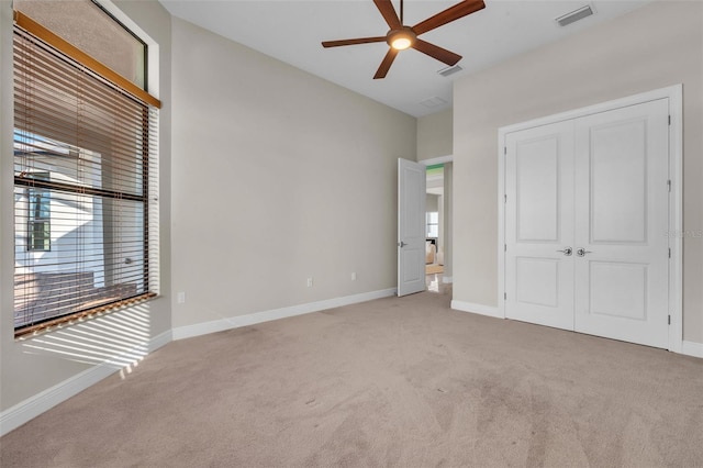 unfurnished bedroom with baseboards, visible vents, and carpet