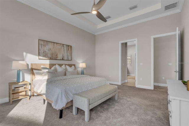bedroom featuring visible vents, a raised ceiling, light colored carpet, and crown molding
