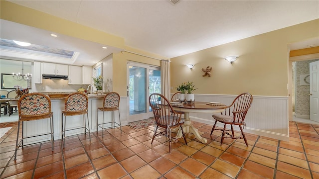 tiled dining space with an inviting chandelier