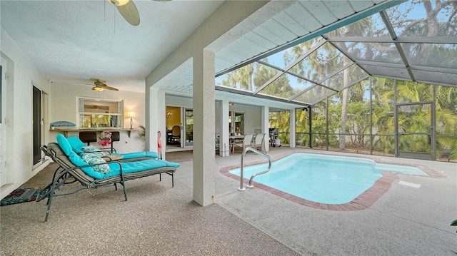 view of pool with ceiling fan, glass enclosure, and a patio area