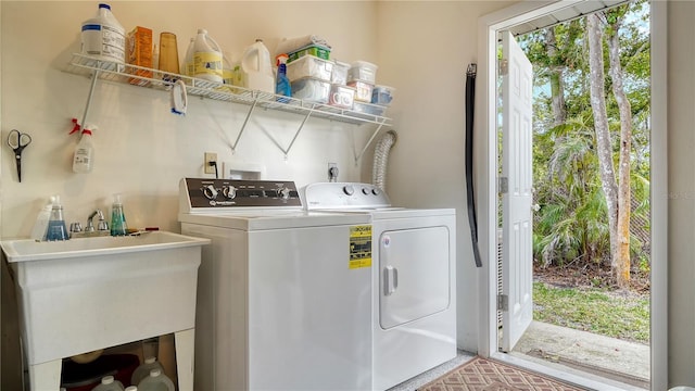 clothes washing area featuring independent washer and dryer and sink