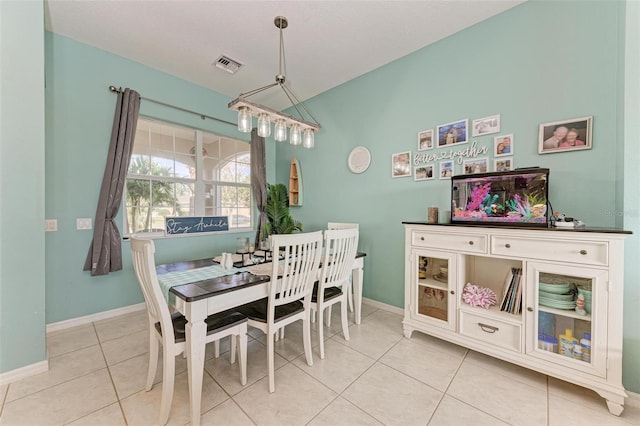 tiled dining space with a chandelier