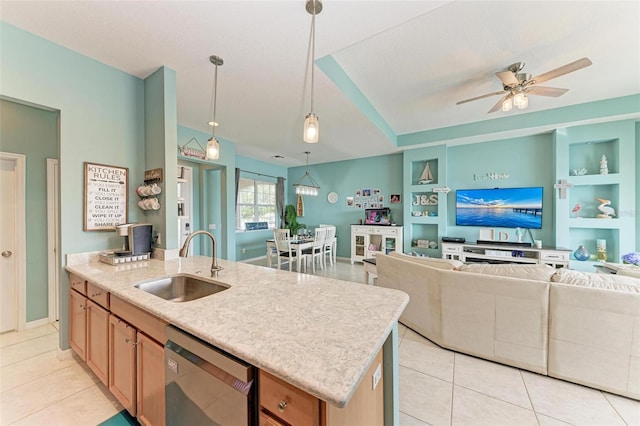 kitchen featuring pendant lighting, sink, stainless steel dishwasher, built in features, and an island with sink