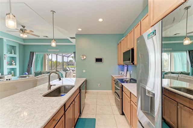 kitchen with ceiling fan, sink, built in features, decorative light fixtures, and appliances with stainless steel finishes