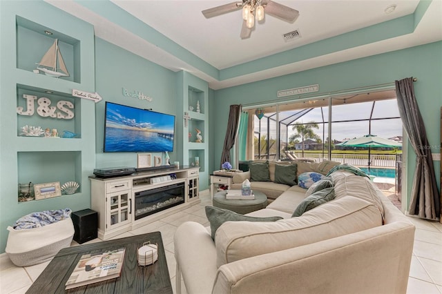 tiled living room with ceiling fan and built in features