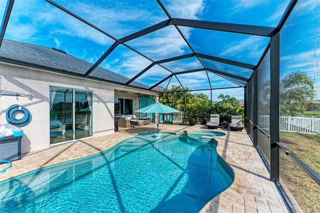 view of pool featuring glass enclosure, an in ground hot tub, and a patio