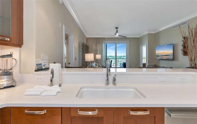 kitchen featuring dishwashing machine, ceiling fan, crown molding, and sink