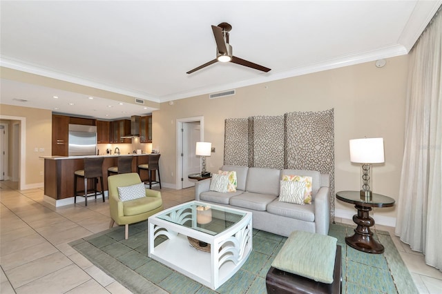 tiled living room featuring ceiling fan and crown molding