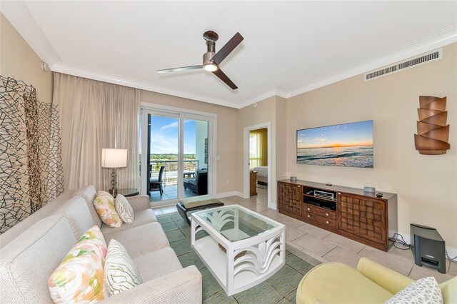 living room featuring ceiling fan, crown molding, and light tile patterned floors