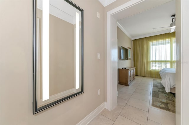 hall featuring light tile patterned floors and crown molding