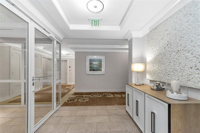 corridor featuring light tile patterned floors, a raised ceiling, and crown molding