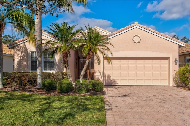 mediterranean / spanish house featuring a garage and a front lawn