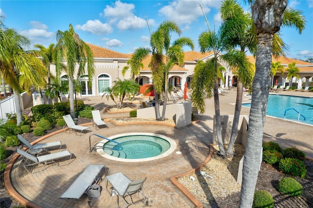 view of pool with a patio area and a hot tub