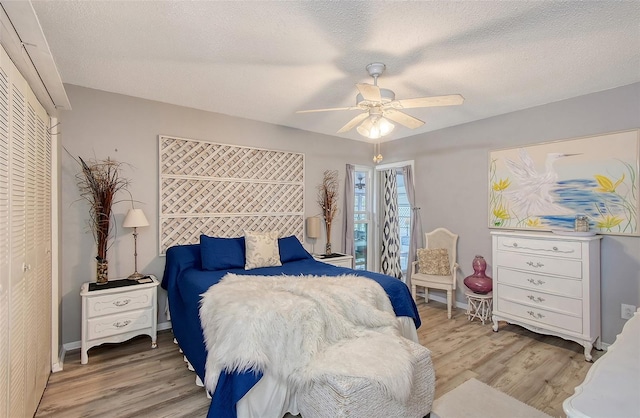 bedroom featuring ceiling fan, a closet, wood-type flooring, and a textured ceiling