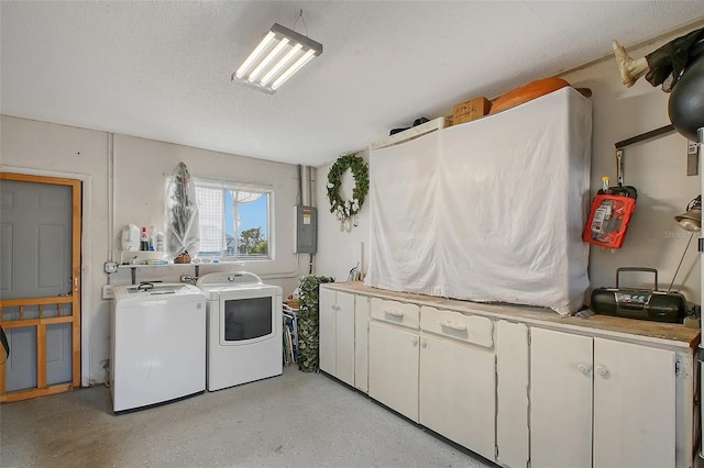 washroom with cabinets, independent washer and dryer, a textured ceiling, and electric panel