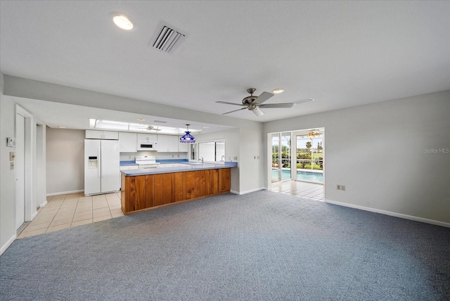 kitchen with white appliances, white cabinets, ceiling fan, light colored carpet, and kitchen peninsula