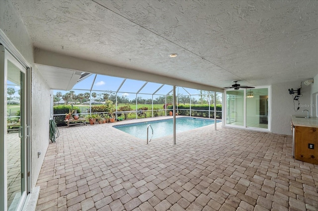 view of pool with a patio, ceiling fan, a lanai, and sink