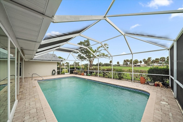 view of pool featuring glass enclosure and a patio area