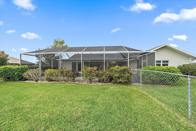 rear view of property with a lanai and a lawn