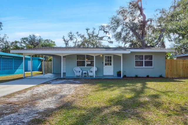 ranch-style house with a front yard, a porch, and a carport