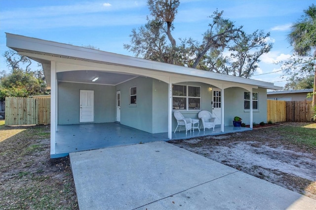 ranch-style house with covered porch and a carport