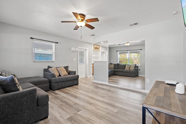 living room with ceiling fan and light hardwood / wood-style flooring