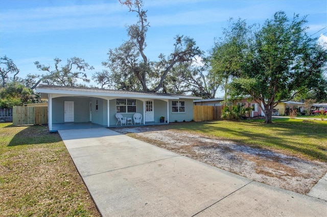 single story home with a front lawn, fence, stucco siding, a carport, and driveway