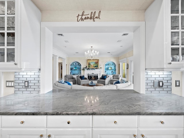 kitchen with white cabinetry, stone counters, and decorative backsplash