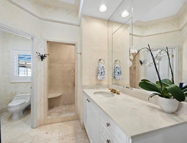 bathroom with toilet, tiled shower, and vanity